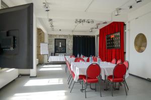 a conference room with tables and red chairs and a flat screen tv at chillten dorsten in Dorsten