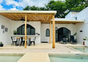 a patio with a table and chairs next to a pool at Las Guapas Villas Tamarindo in Tamarindo