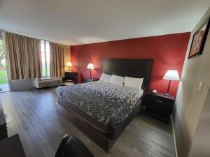 ein Hotelzimmer mit einem Bett und einer roten Wand in der Unterkunft Econolodge in Andalusia