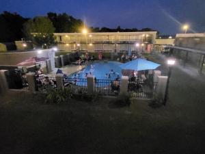 einen Pool in der Nacht mit Leuten um ihn herum in der Unterkunft Econolodge in Andalusia