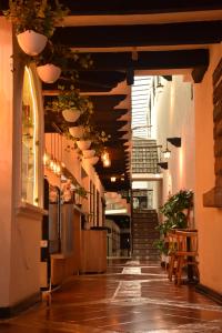 une allée avec des escaliers et des plantes en pot dans un bâtiment dans l'établissement Rosario Hotel, à San Cristóbal de Las Casas