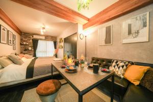 ein Schlafzimmer mit einem Bett, einem Tisch und einem Sofa in der Unterkunft Cooee Sapporo in Sapporo
