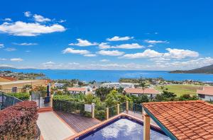 a view of the ocean from the balcony of a house at Airlie Hasta Manana in Airlie Beach