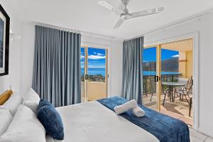 a bedroom with a bed and a couch and a balcony at Airlie Hasta Manana in Airlie Beach