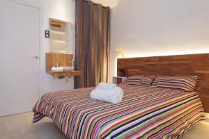 バルセロナにあるラダスのベッドルーム1室(ストライプ毛布付きのベッド1台付)