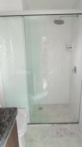 um chuveiro com uma porta de vidro na casa de banho em Departamento Único, Respiro verde em Santa Cruz de la Sierra