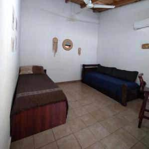 ein Schlafzimmer mit einem Bett und einem Sofa in einem Zimmer in der Unterkunft Casa para 6 con cochera-Maragus in Posadas