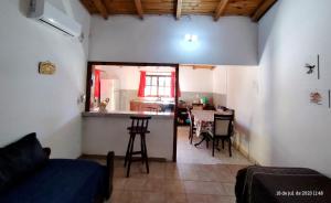 ein Wohnzimmer mit einem Sofa und einem Tisch sowie eine Küche in der Unterkunft Casa para 6 con cochera-Maragus in Posadas