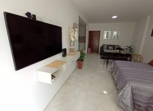 a living room with a large flat screen tv on a wall at Departamento Único, Respiro verde in Santa Cruz de la Sierra