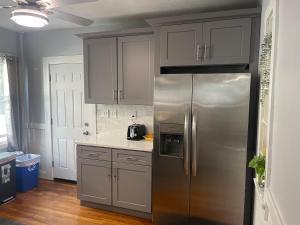 a kitchen with a stainless steel refrigerator and white cabinets at Boston Luxury 2 Bedroom Private Condo in Boston