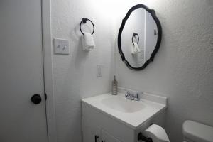 ein weißes Badezimmer mit Waschbecken und Spiegel in der Unterkunft Chic & Cozy 2 bedroom - 1 bathroom - RATED BEST in Eagle Pass + 29 Fotos