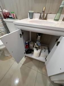 einen offenen Schrank unter einem Waschbecken im Bad in der Unterkunft Comfy 2 bedroom apartment in Port Richey