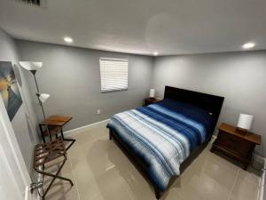 ein Schlafzimmer mit einem Bett, einem Tisch und einer Lampe in der Unterkunft Comfy 2 bedroom apartment in Port Richey