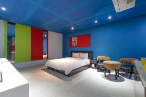 1 dormitorio con 1 cama con paredes y sillas coloridas en Incheon Pentastar Hotel en Incheon