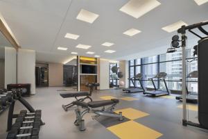 a gym with treadmills and ellipticals in a building at The Meixi Lake, Changsha Marriott Executive Apartments in Changsha