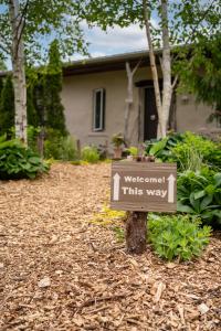 een bord op een boom voor een huis bij Owl's Nest Suites in Carrying Place