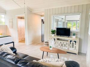 a living room with a couch and a tv at Monstera Bungalow, Spacious, King Bed, Big Kitchen in Keaau