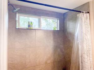a bathroom with a shower with a window at Monstera Bungalow, Spacious, King Bed, Big Kitchen in Keaau +20 photos