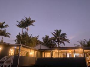 a house with palm trees in front of it at Monstera Bungalow, Spacious, King Bed, Big Kitchen in Keaau