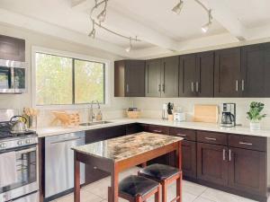 a kitchen with wooden cabinets and a counter top at Monstera Bungalow, Spacious, King Bed, Big Kitchen in Keaau