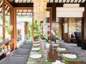 - une longue table avec des assiettes et des verres à vin dans l'établissement Villa Simona Oasis, à Canggu