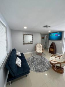 een woonkamer met een blauwe bank en 2 stoelen bij Lovely 2 bedroom apartment in Port Richey