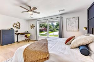 a bedroom with a bed with a ceiling fan and a desk at Savannah Place: Mid-Century Modern 3 Bedroom Home in Savannah