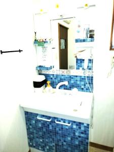 La salle de bains est pourvue d'un lavabo et d'un miroir. dans l'établissement シーカレント　ゆな　CHIKURA, à Chikura
