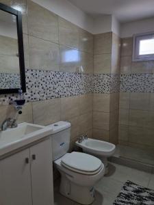 a bathroom with a toilet and a sink and a tub at Bella Vista in Cipolletti +3 photos