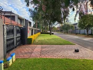 a brick walkway next to a house with a fence at Trumma Guest House in Pretoria