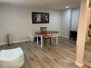 a living room with a table and a chair at A Bright Specious 1 Bedroom Unit in the Basement in Ottawa