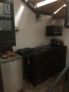 una pequeña cocina con fregadero y microondas en Maru's House en Guadalajara