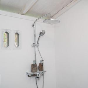 a shower in a bathroom with a white wall at Aranka Tempasan in Sangyang
