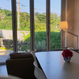 a room with a table with a vase of flowers on it at A shell in Jeju in Seogwipo