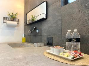 a bathroom with a tray of food and bottles of water at Antia Valle de Guadalupe in Valle de Guadalupe