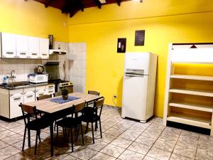 a kitchen with a table and a white refrigerator at Apart Belgrano in Puerto Iguazú