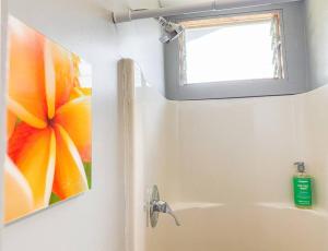 uma casa de banho com um lavatório com uma fotografia de uma flor em Surf Getaway, Queen Bed, Private Lanai em Keaau