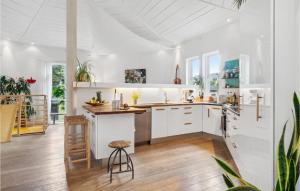 uma cozinha com armários brancos e piso em madeira em Lovely Home In Gilleleje With Kitchen em Gilleleje