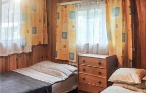 a bedroom with two beds and a dresser and a window at 2 Bedroom Pet Friendly Home In Popowo-letnisko 