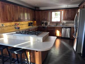 a kitchen with wooden cabinets and a stove top oven at Indoor pool, hot tub, sauna! in Colorado Springs