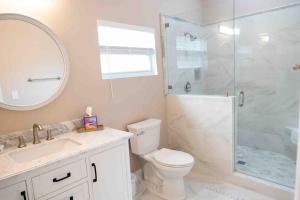 a bathroom with a toilet and a glass shower at Tampa Bay Oasis in Tarpon Springs