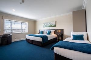 Postel nebo postele na pokoji v ubytování Tuakau Hotel