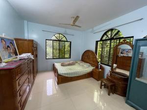 a bedroom with a bed and a dresser and windows at Dream house in Atgaon