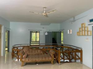a living room with a couch and a ceiling fan at Dream house in Atgaon