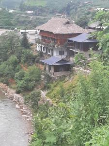 una casa su una collina vicino a un fiume di Dong Suoi H'mong Homestay & Bungalow a Mù Cang Chải