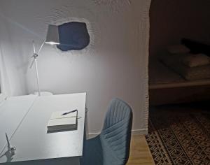 een kamer met een bureau met een lamp en een stoel bij Nice apartament with small tub in Warschau