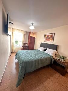 1 dormitorio con 1 cama con edredón verde en Hotel Palmas Reales, en Trujillo