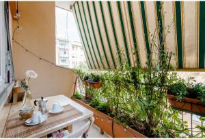 a balcony with a table and a window with plants at Eco B&B Marela in Rome
