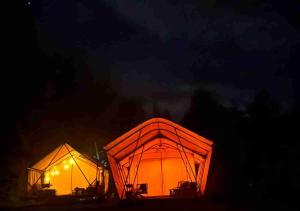 dwa duże pomarańczowe namioty oświetlone nocą w obiekcie Keisaji CAMP SITE - Vacation STAY 90068v w mieście Ijinabaru