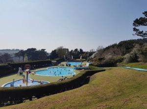 ein großes Schwimmbad in einem Park mit Menschen darin in der Unterkunft Holiday Home with Stunning Views in Newquay